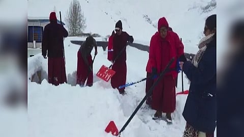 Locals remove snow from road in Kaza