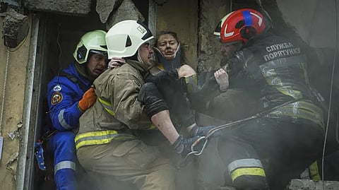 Ukrainian State Emergency Service firefighters carry a wounded woman out of the rubble from a building after a Russian rocket attack on Saturday in Dnipro.