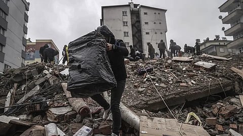 People and emergency teams search for people in the rubble in a destroyed building in Gaziantep, Turkey.