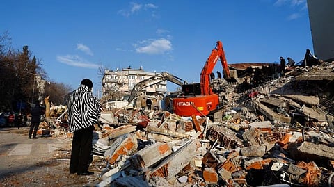 A person looks at rubble and debris following an earthquake in Kahramanmaras