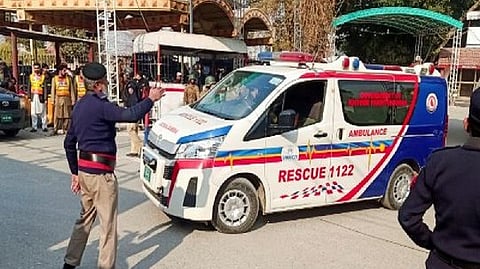 A police officer guides an ambulance after the suicide blast at a mosque in Peshawar