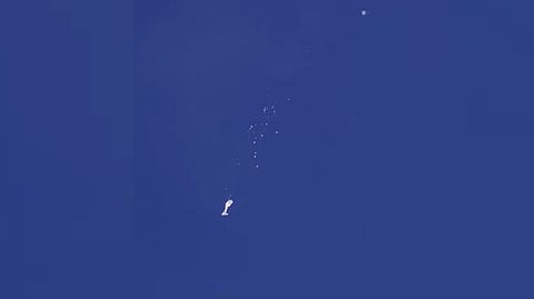 The remnants of a large balloon descend after it was struck by a missile