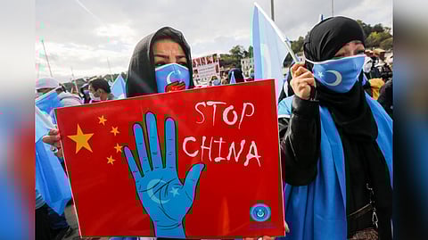 Ethnic Uighur demonstrators take part in a protest against China