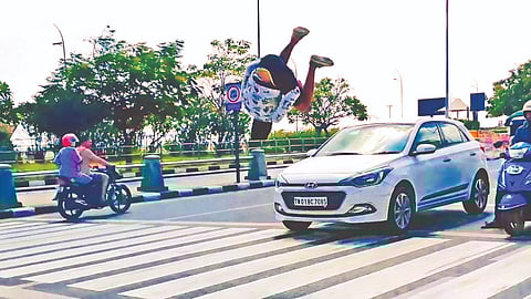 A youth showing off his gymnastic skills on Kamarajar Salai near Marina beach