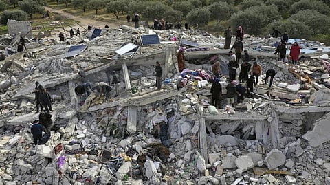Civil defense workers and residents search through the rubble of collapsed buildings in the town of Harem near the Turkish border, Idlib province, Syria, Monday.