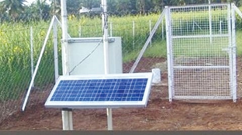 An automated weather station near a field
