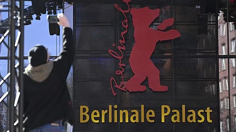 A person holds a mobile device in front of the 'Berlinale Palace', home of the Berlinale film festival, in Berlin, Germany.