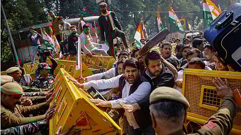 Activists of the youth wing of India's main opposition Congress party try to break a police barricade during a protest against what they say investments by Life Insurance Corporation (LIC) and State Bank of India (SBI) in Adani