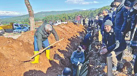 People bury victims of the deadly earthquake, at a cemetery in Kahramanmaras, Turkey