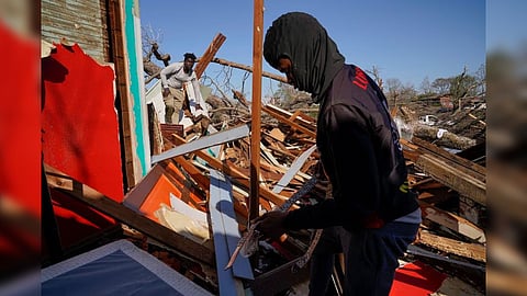 The son and nephew of Cedric Miles search for belongings inside the Miles family home after thunderstorms spawning high straight-line winds and tornadoes ripped across the state in Rolling Fork, Mississippi, U.S. March 25, 2023