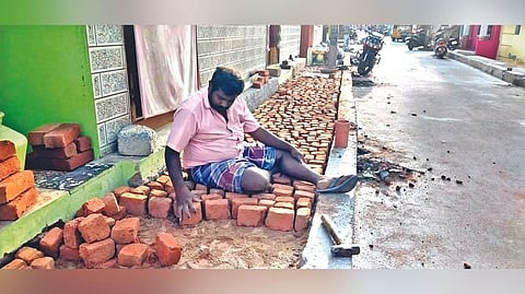 A resident of Vijayaraghavapuram filling the half done pavement
with bricks and concrete mix in Sathuvachary, Vellore.