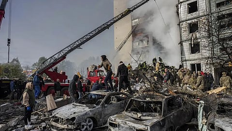 Following a Russian attack, first responders remove rubble at a residential building