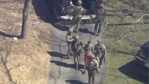 Jack Teixeira, in T-shirt and shorts, being taken into custody by armed tactical agents on Thursday, April 13, 2023, in Dighton, Mass. A judge is expected to hear arguments Thursday, April 27, over whether Teixeira, accused of leaking highly classified military documents about the Ukraine war and other issues, should remain in jail while he awaits trial.