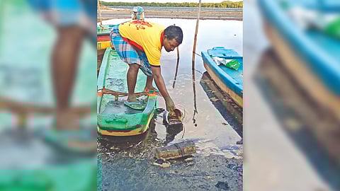 A fisherman collects polluting substance