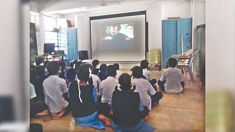 Students watching a film clip to identify prevalent stereotypes in media