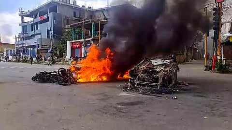 Vehicles in flames after violence broke out, in Imphal.