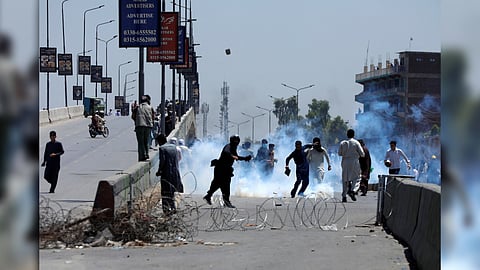 Supporters of Pakistan's former Prime Minister Imran Khan throw stones towards police during a protest against Khan's arrest, in Peshawar, Pakistan, May 10, 2023
