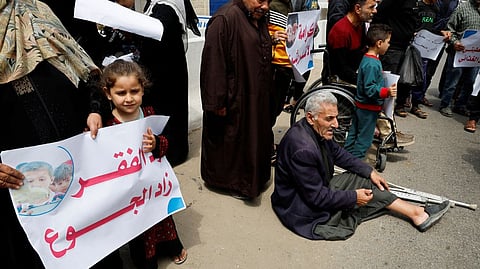 Palestinians attend a gathering outside UN offices to protest a decision by World Food Program to suspend aid of around 200,000 people in the Gaza Strip and the West Bank