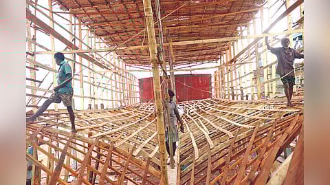 Contract workers building the structure of a boat.