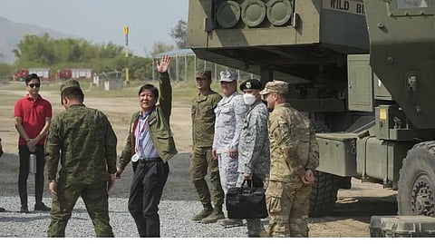 Philippine President Ferdinand Marcos Jr. waves beside a U.S. M142 High Mobility Artillery Rocket System (HIMARS) during a Combined Joint Littoral Live Fire Exercise at the joint military exercise called "Balikatan," Tagalog for shoulder-to-shoulder in a Naval station in Zambales province, northern Philippines