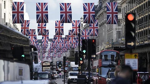 Traffic moves through the decorated Regent Street in central London Friday, May 5, 2023. The Coronation of King Charles III will take place at Westminster Abbey on May 6.