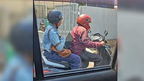 Women working on a rapido bike ride in Bangalore traffic