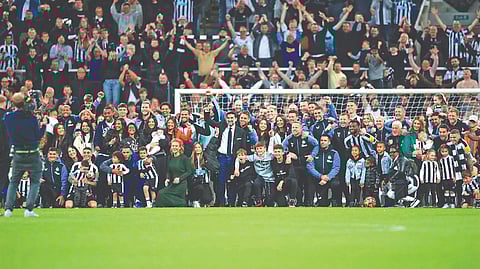Newcastle United players, staff and management members celebrate qualifying for the Champions League