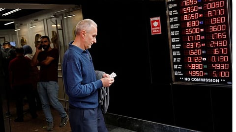 A man counts his money as he leaves a currency exchange office in Istanbul, Turkey