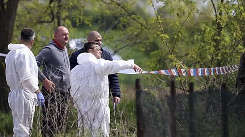 Forensic police inspect the scene around a car in the village of Dubona, some 50 kilometers (30 miles) south of Belgrade, Serbia, Friday, May 5, 2023.