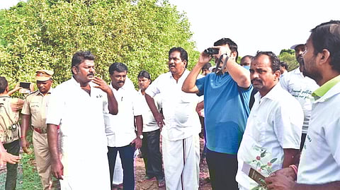 Minister M Mathiventhan using a binocular to view a biodiversity spot at Idayapatti in Madurai on Sunday