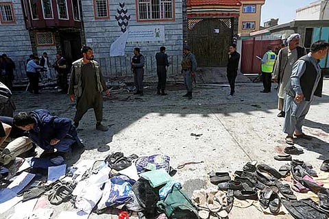 People gather outside a voter registration centre, which was attacked by a suicide bomber in Kabul