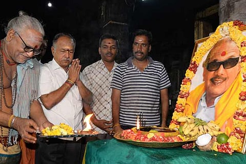 A group of mourners joining a pooja for the leader?s soul to rest in peace