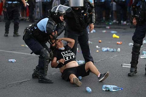 Police stand near protester during a demonstration in Bucharest