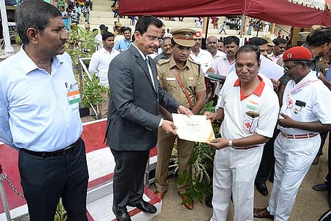 Vellore Collector SA Raman hands over a certificate to a teacher on Wednesday