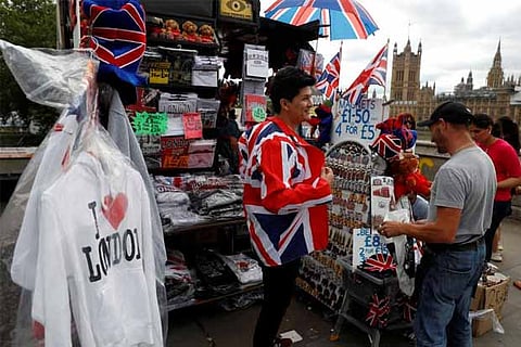 A man tries on a Union Jack themed jacket at a souvenir stall in London