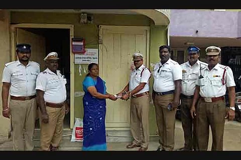 The traffic policemen handing over the demand draft for Rs 40,000 to Vanathammal
