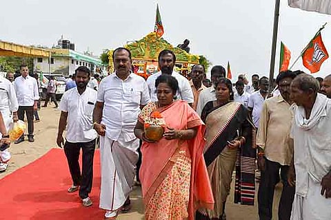 State BJP president carries the urn containing the ashes of Vajpayee before immersing at the Elliots