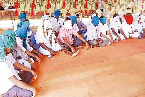 Farmers cover their face with a cloth in Salem on Sunday, protesting against the project