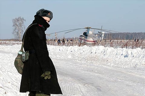 A Russian serviceman looks back as he stands guard during a search operation near the crash site,