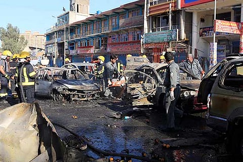 Afghan policemen inspect the site of a blast in Jalalabad city, Afghanistan