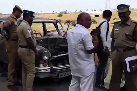 Police officers inspecting the car that was set on fire near Minjur on Friday