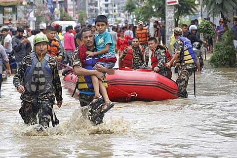 Nepalese army men rescue a sick boy from a flooded area in Bhaktapur, Nepal