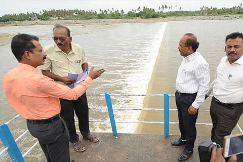 Karur Collector T Anbalagan inspects the flow at Manmangalam check dam along with officials