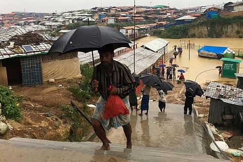 Rohingya refugees walks along the refugee camp during rain in Cox?s Bazar