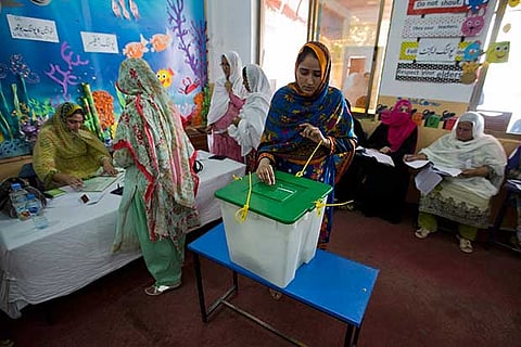 A Pakistani woman casts her vote at a polling station for the parliamentary elections