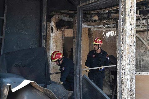 Greek firefighters go through debris.(AFP)