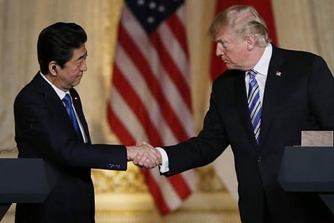 US President Donald Trump (R) and Japan's Prime Minister Shinzo Abe shake hands