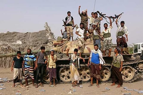 Tribal fighters loyal to the Yemeni government stand by a tank in al-Faza area near Hodeida, Yemen
