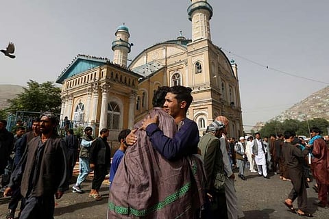 Afghans greet each other outside the Shah-e Doh Shamshira Mosque, on the first day of Eid al-Fitr