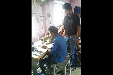 A cobbler busy in mending a footwear at Flying Cobbler